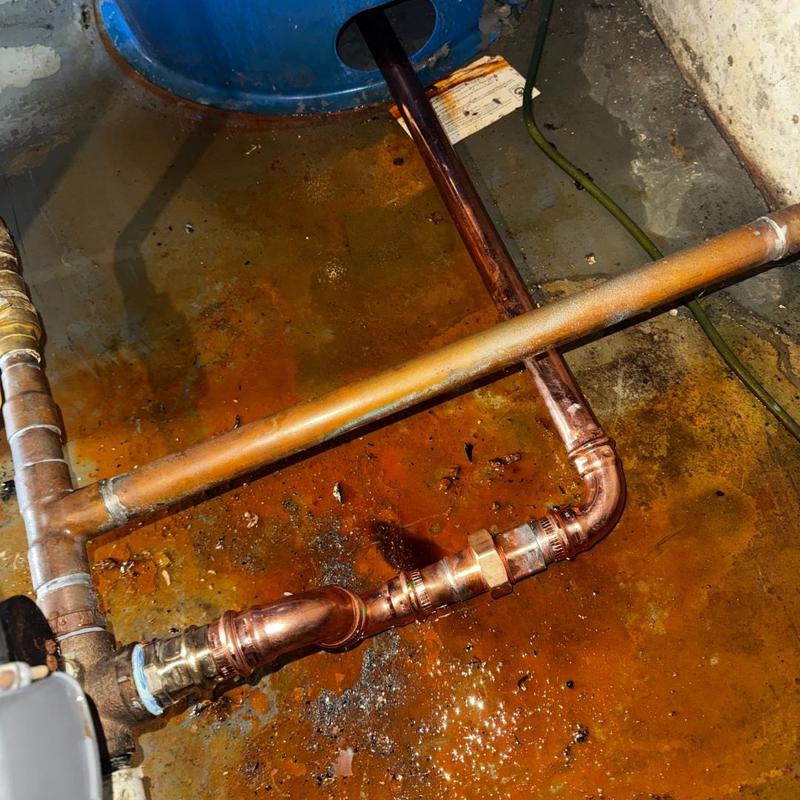 Copper pipe and brass fittings near pressure tank leak
