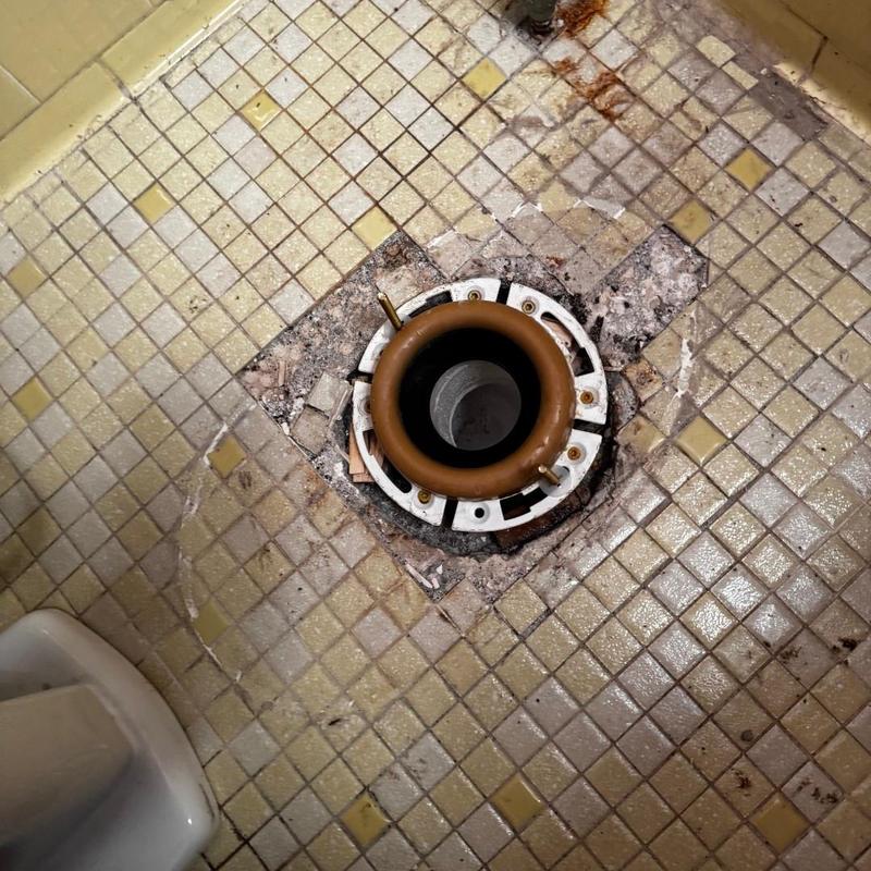 Toilet flange replacement on tiled bathroom floor