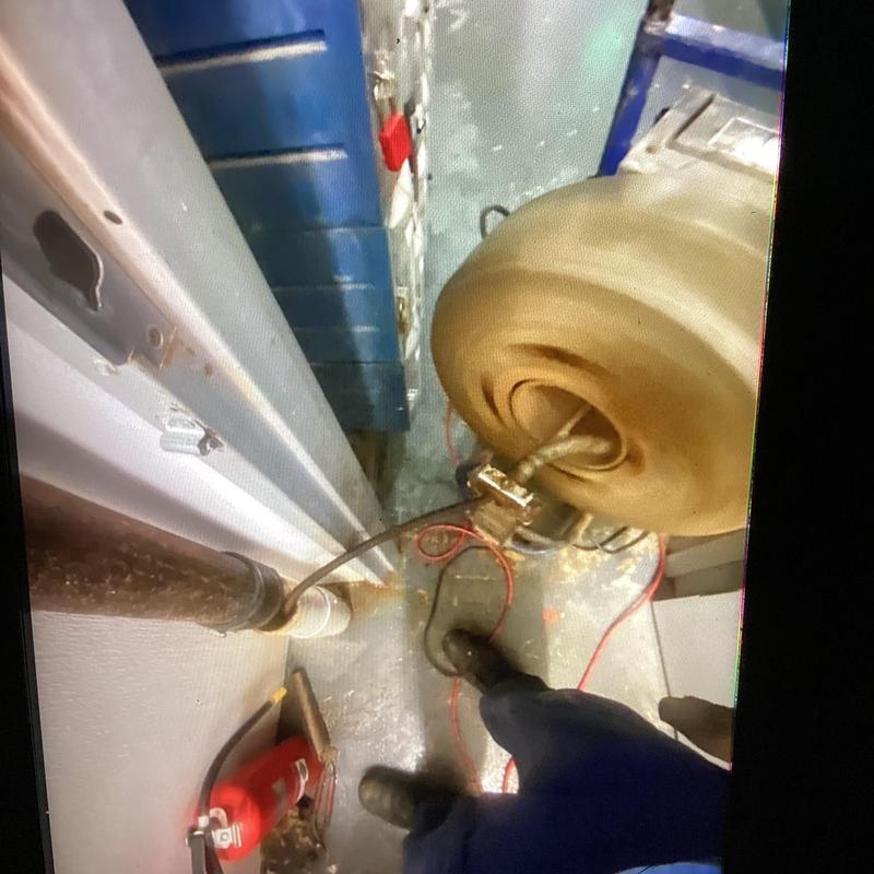 Floor drain and cleanout with cable in restroom