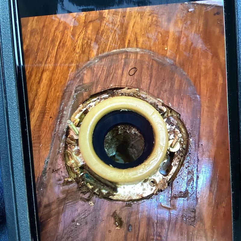 Toilet flange on wooden floor with bolts and wax ring