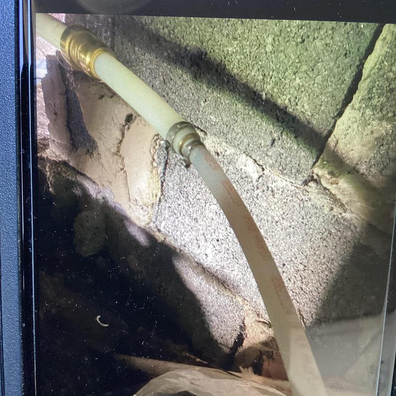Flexible hose connection in crawl space near block wall