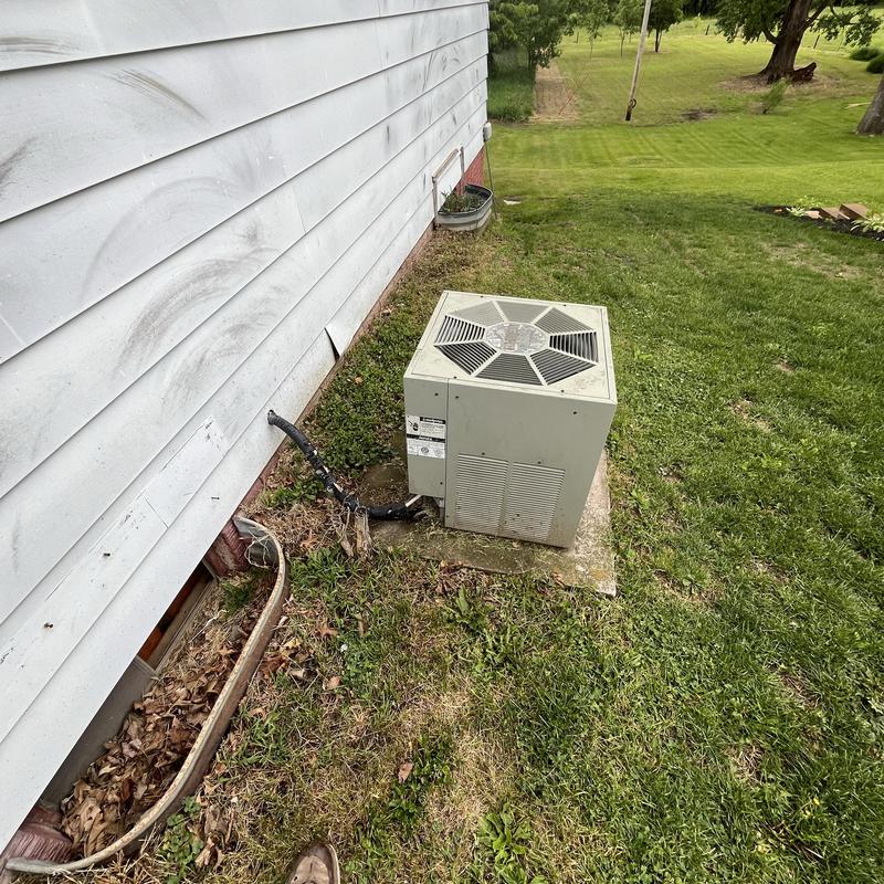 Rheem outdoor air conditioner unit beside house