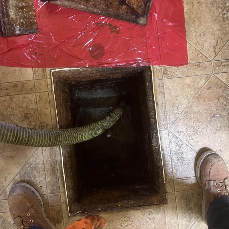 Septic tank pump-out hose inside access opening Septic tank pump-out hose inside access opening