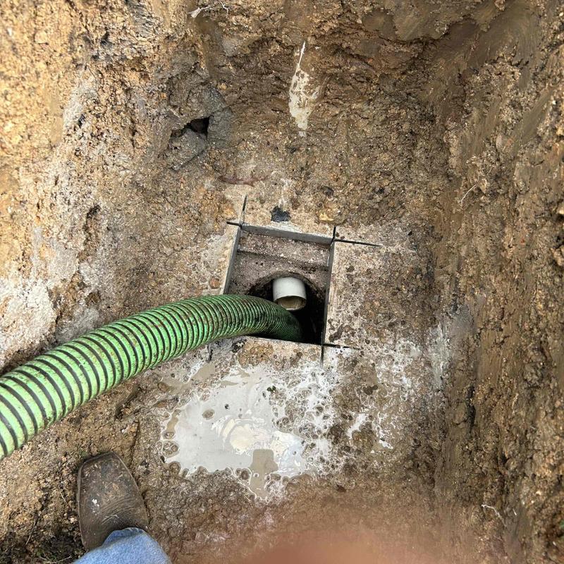 Septic tank pumping with green hose and riser installation