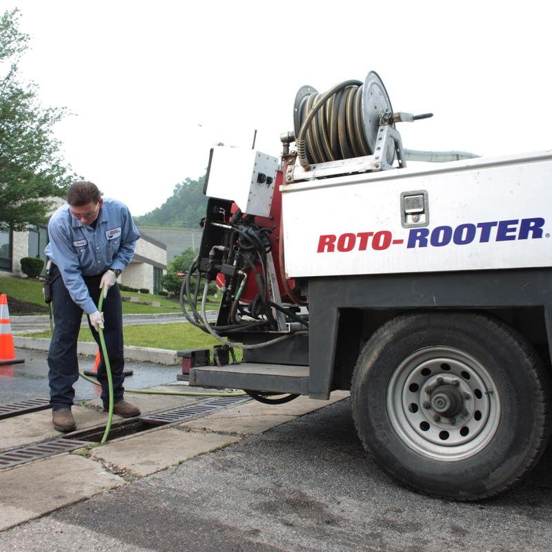 Commercial drain cleaning with Roto-Rooter truck and hose