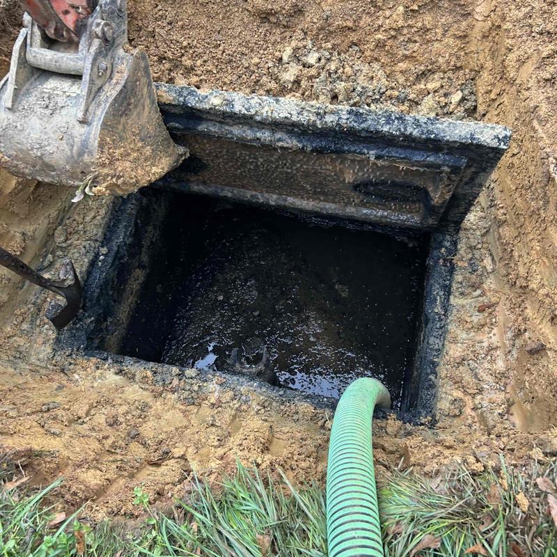 Septic tank excavation and pumping with hose and excavator