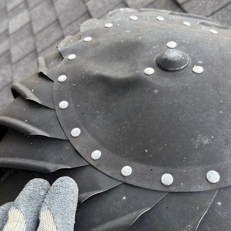 Roof vent cover showing hail damage and dents