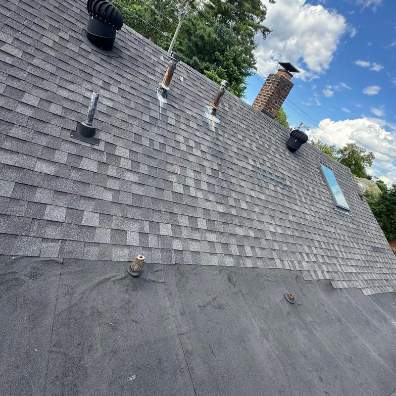 Asphalt shingle and flat roof with vent pipes and chimney
