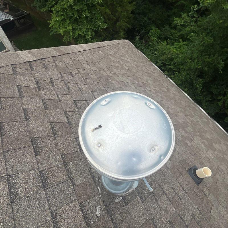 Roof shingles with hail damage near vent pipe