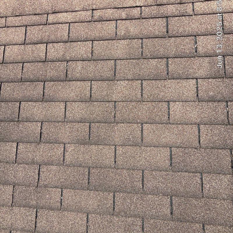 Asphalt shingle roof with signs of aging and hail damage