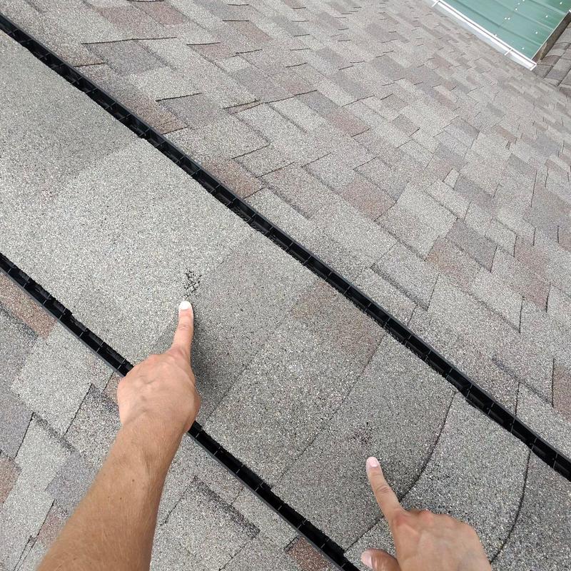 Asphalt roofing shingles with hail damage marks