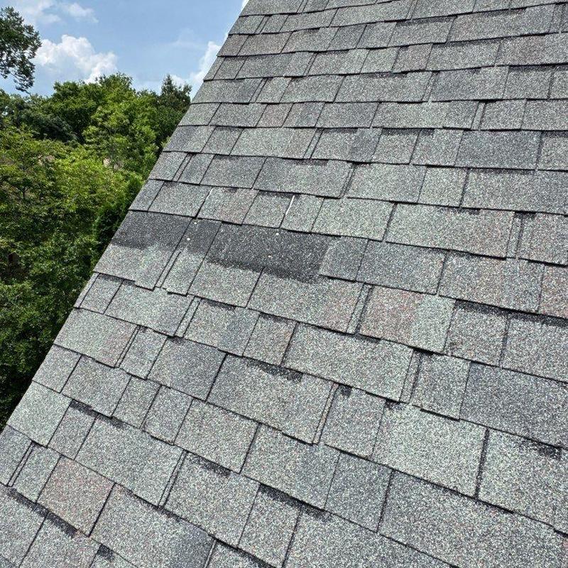 Asphalt roof shingles with visible hail damage