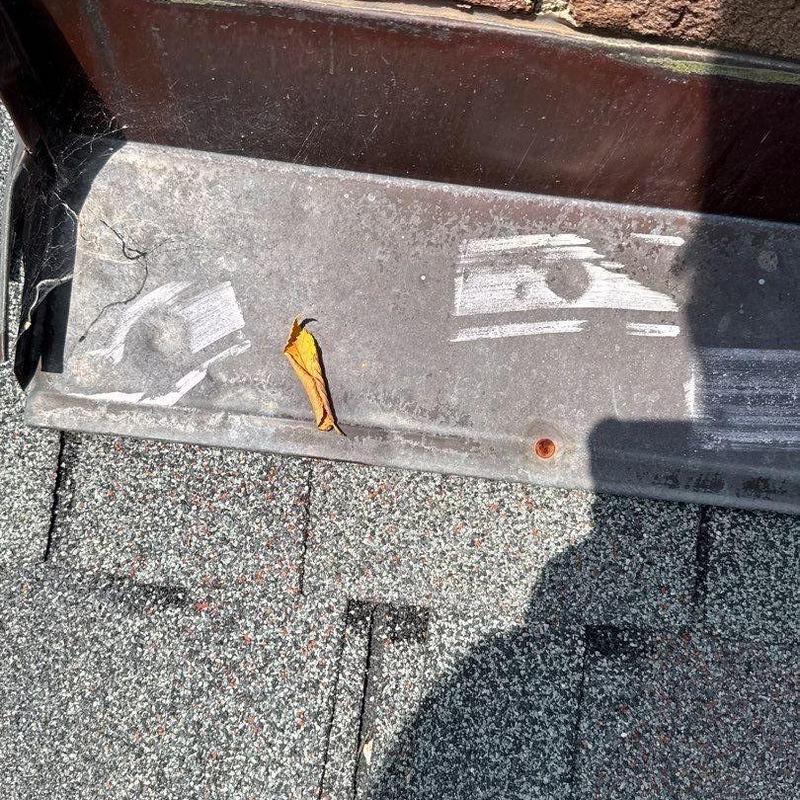 Metal roof flashing with surface damage and debris