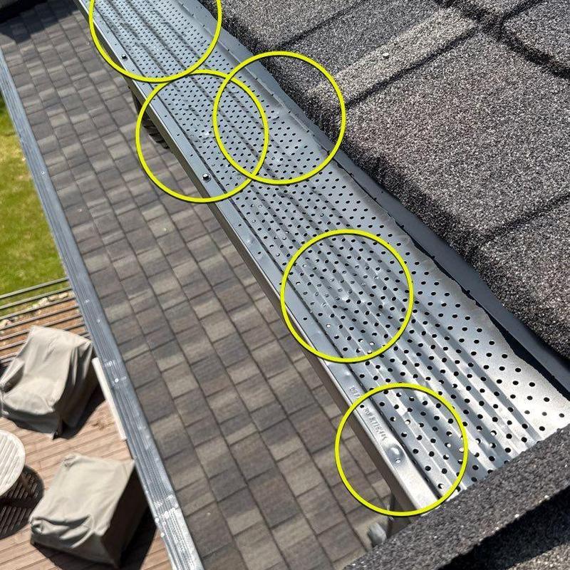 Metal gutter guards with hail damage marked on roof edge
