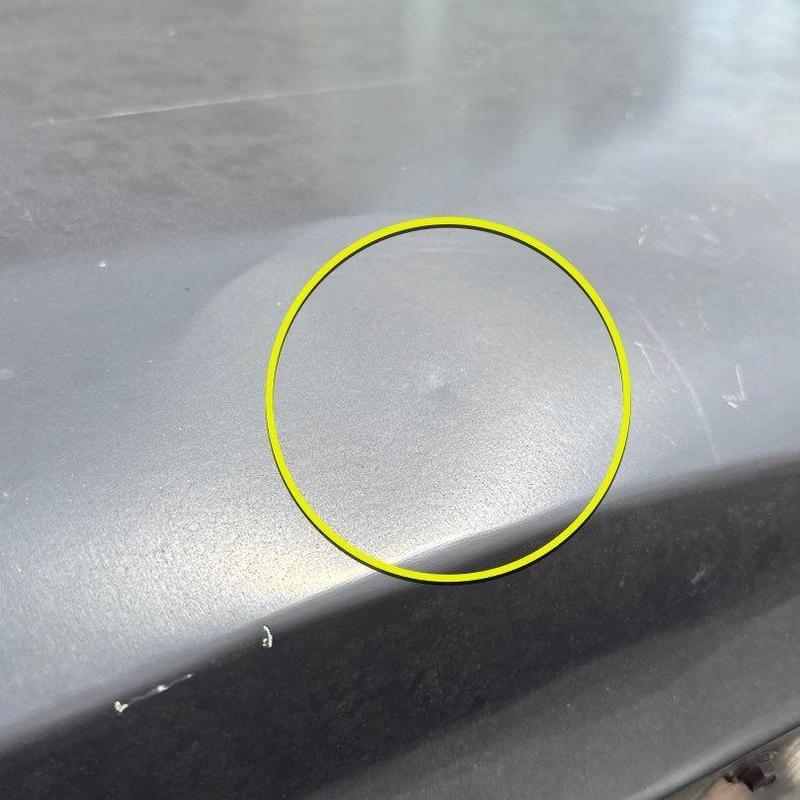 Roof surface with hail impact dent marked by yellow circle