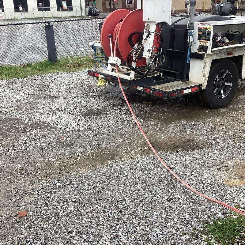 Jetted sewer line hose on utility truck outdoors