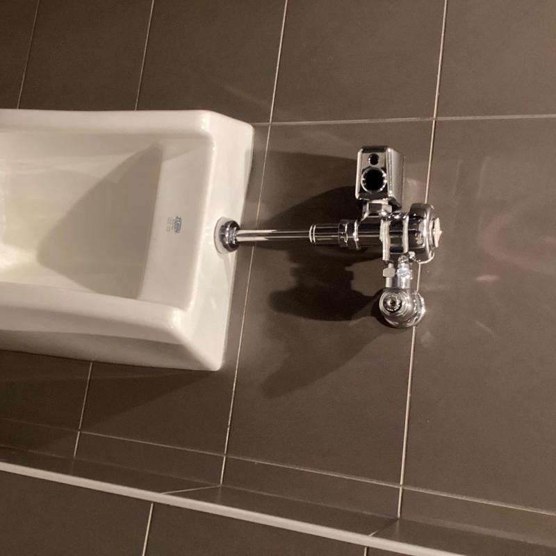 Urinal valve and flush pipe tightening on tiled wall