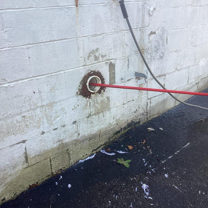 Sewer line jetting through building wall pipe access