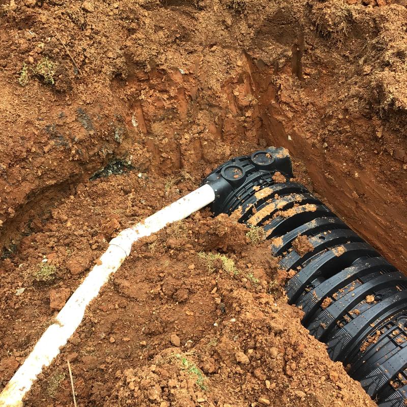 Field drain pipe and catch basin installation in soil