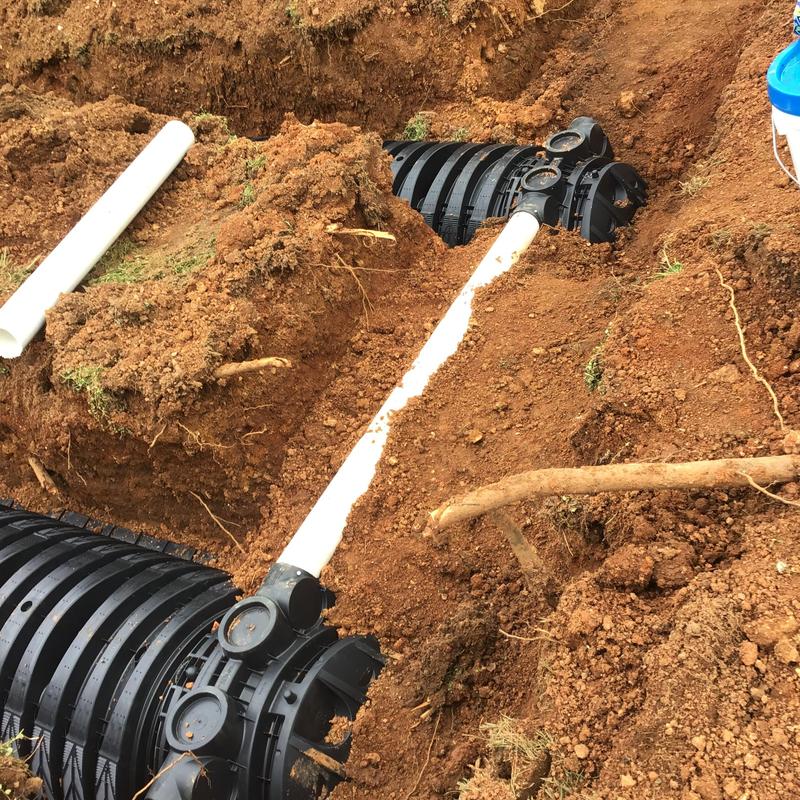 Drain field chambers and PVC pipe installation in soil