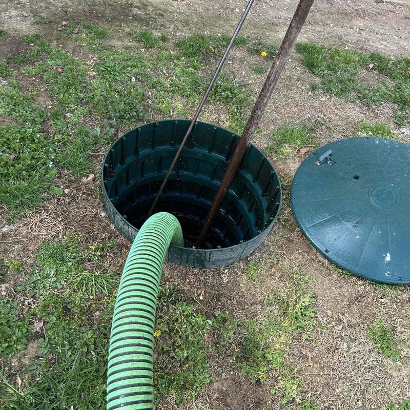 Septic tank with green suction hose outdoors