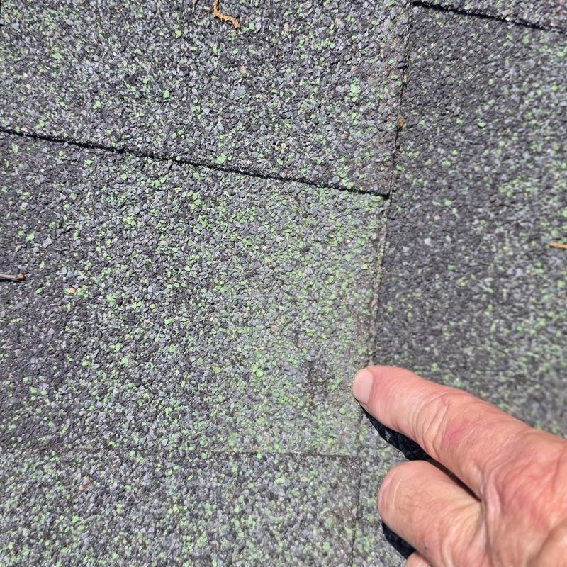 Asphalt roof shingles with hail damage close-up