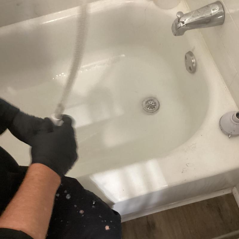 Bathtub drain cleaning with plumbing auger tool
