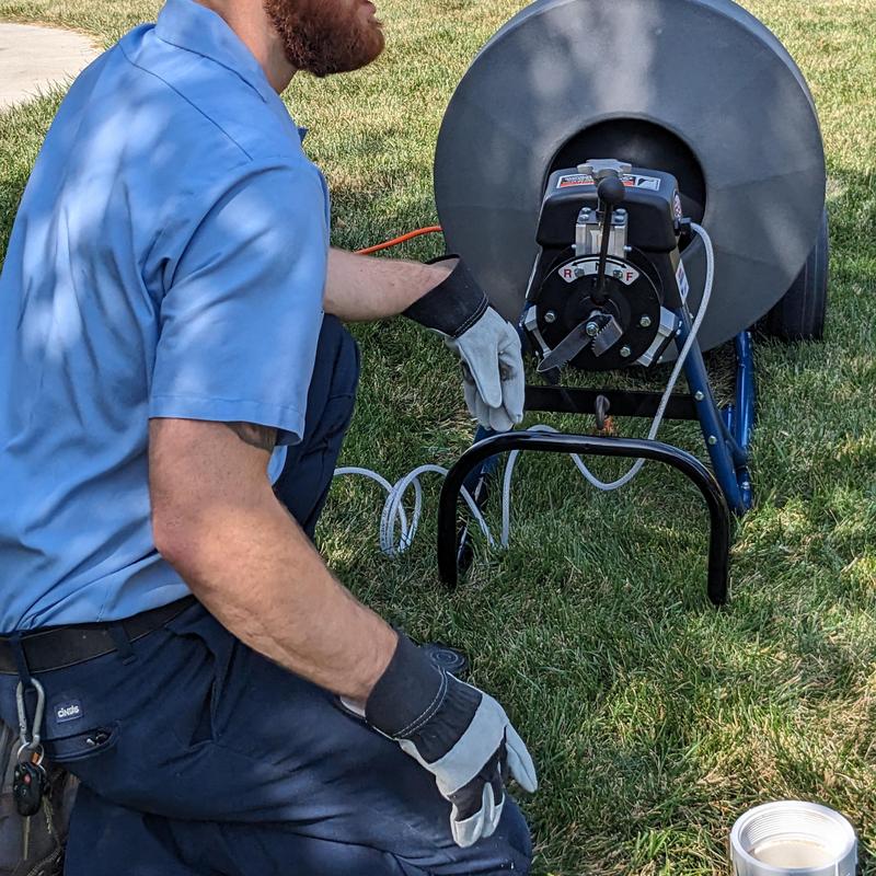 Drain snake machine clearing clogged Airbnb toilets outdoors