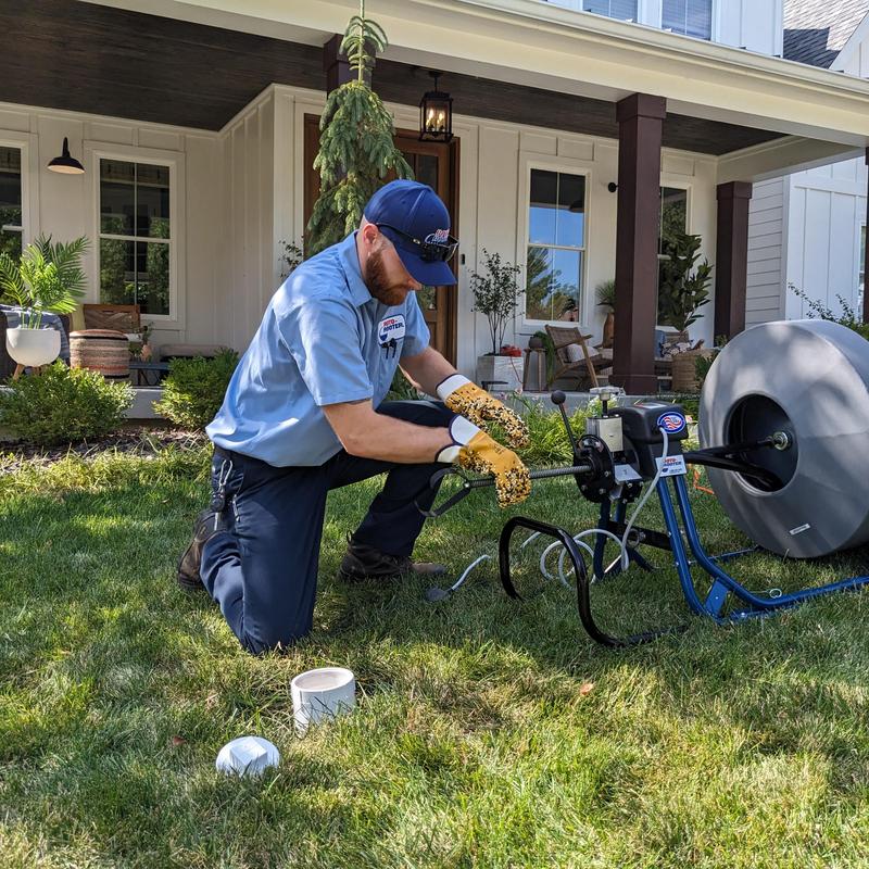 Toilet drain auger setup for clog clearing outdoors