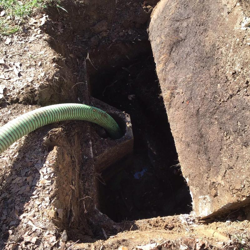 Septic tank inlet baffle with green pump hose
