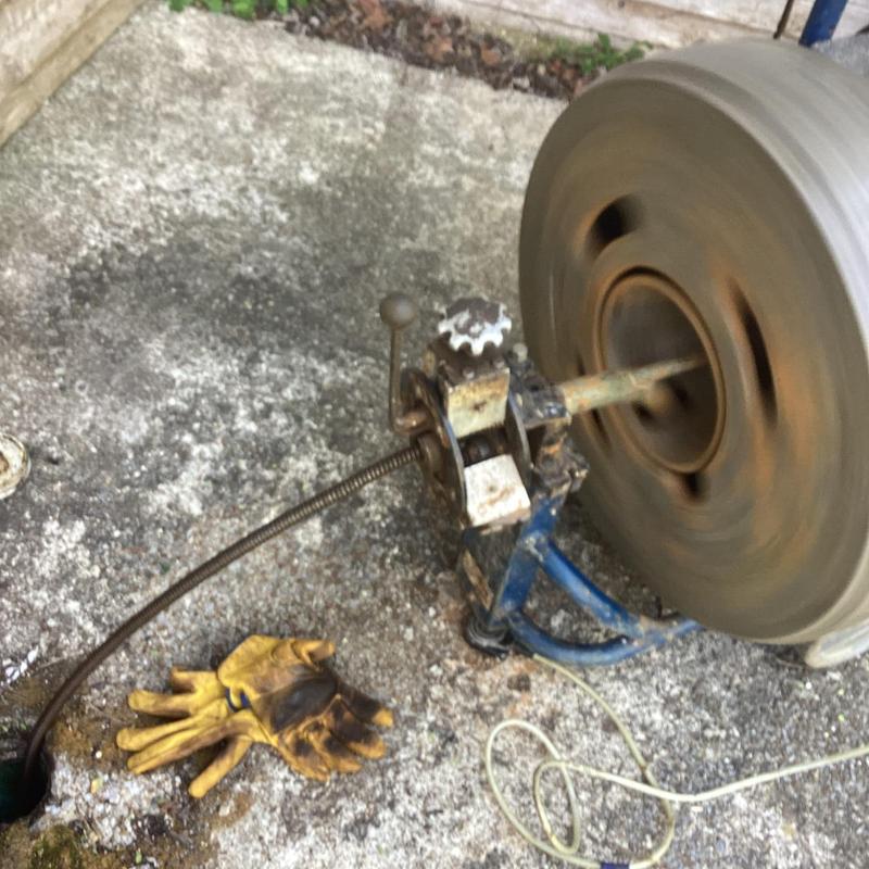 Sewer line cleaning machine operating at cleanout site