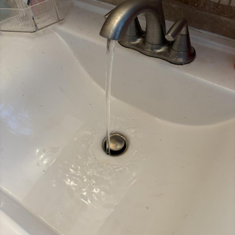 Basin pop-up drain clearing with flowing water