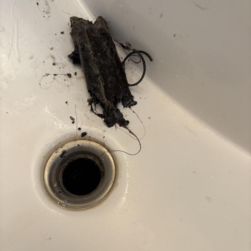 Basin pop-up drain clogged with hair buildup removal