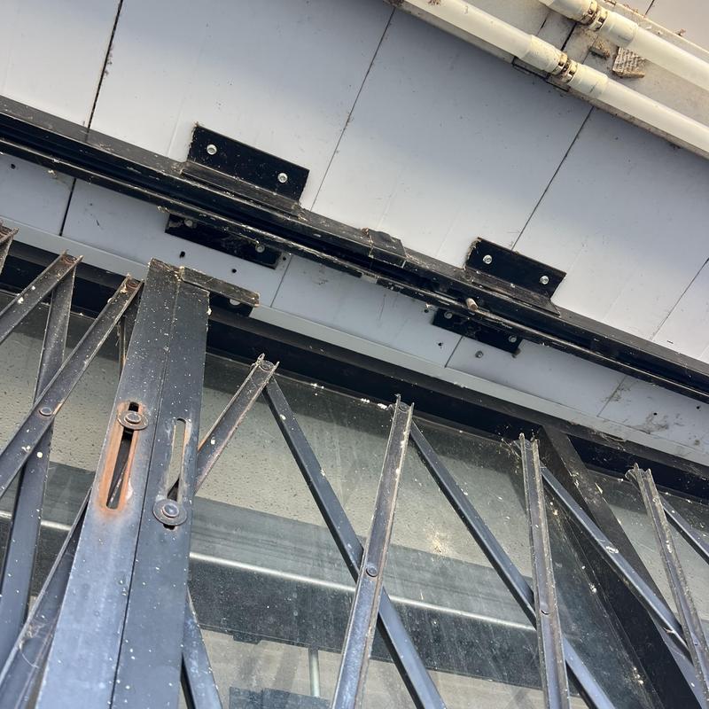 Security gate lock with sliding metal bars on storefront
