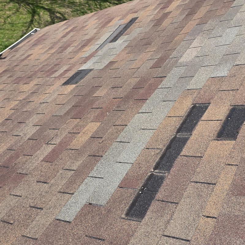 Asphalt shingle roof with hail damage patches