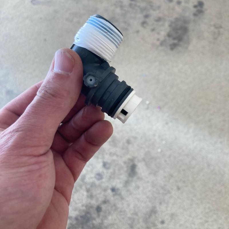 Pressure reducing valve fitting held in hand, close-up