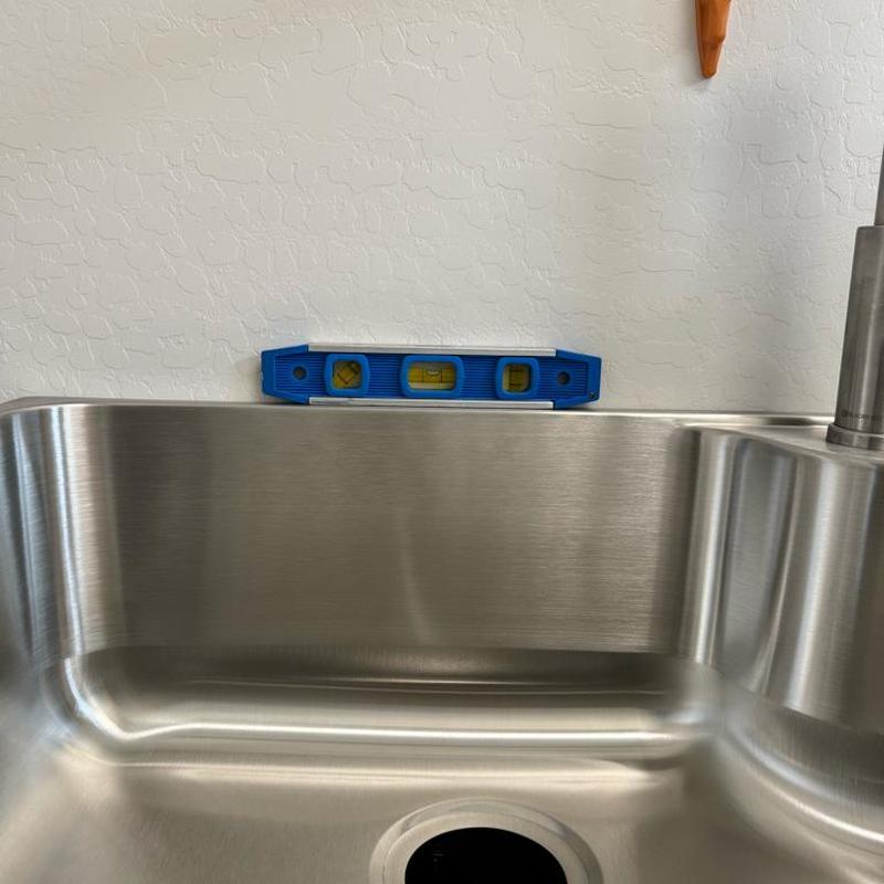 Stainless steel laundry sink with level tool