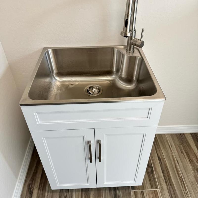 Laundry sink with faucet and white cabinet installation