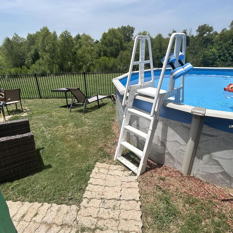 Above ground pool with ladder and patio furniture