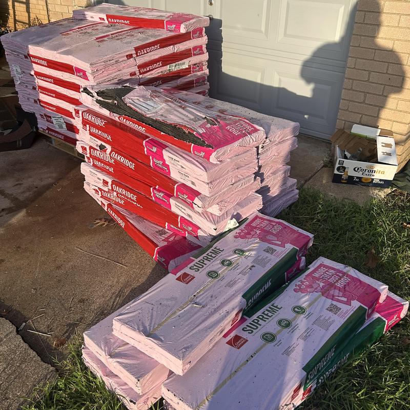 Architectural shingles stacked outdoors for roof installation