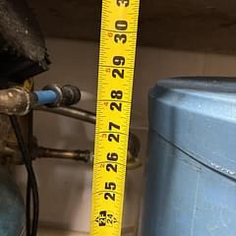 Water softener pipe measurement with yellow tape measure