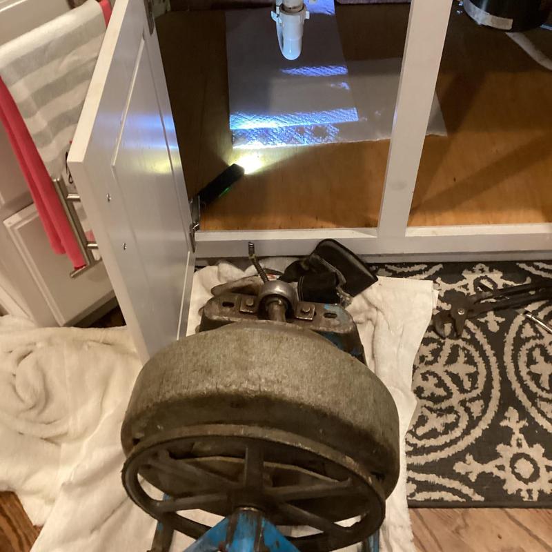 Kitchen sink drain with drain snake under cabinet