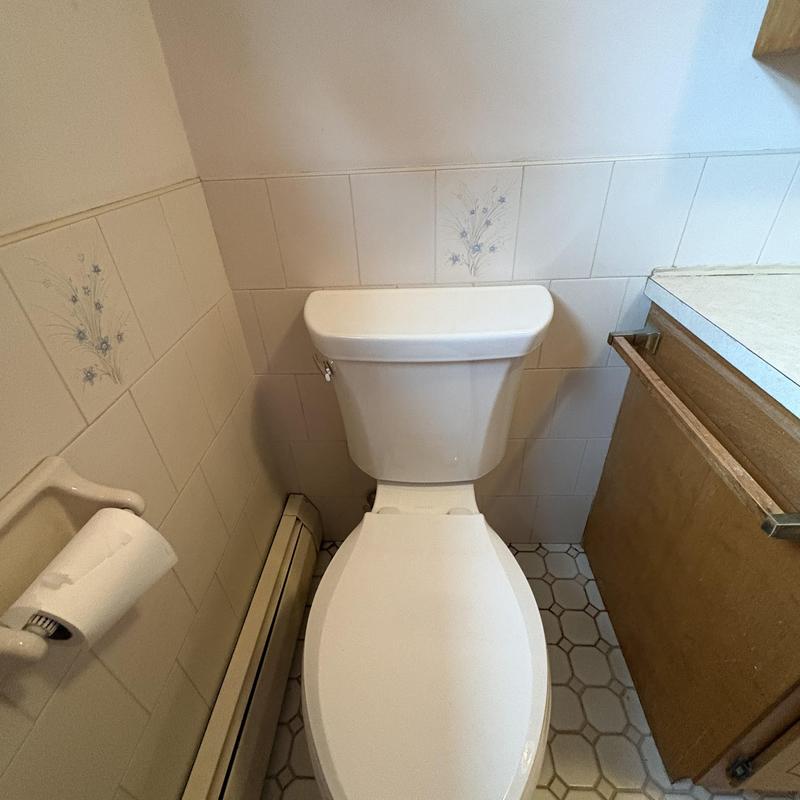 Comfort height elongated Kohler toilet in bathroom corner