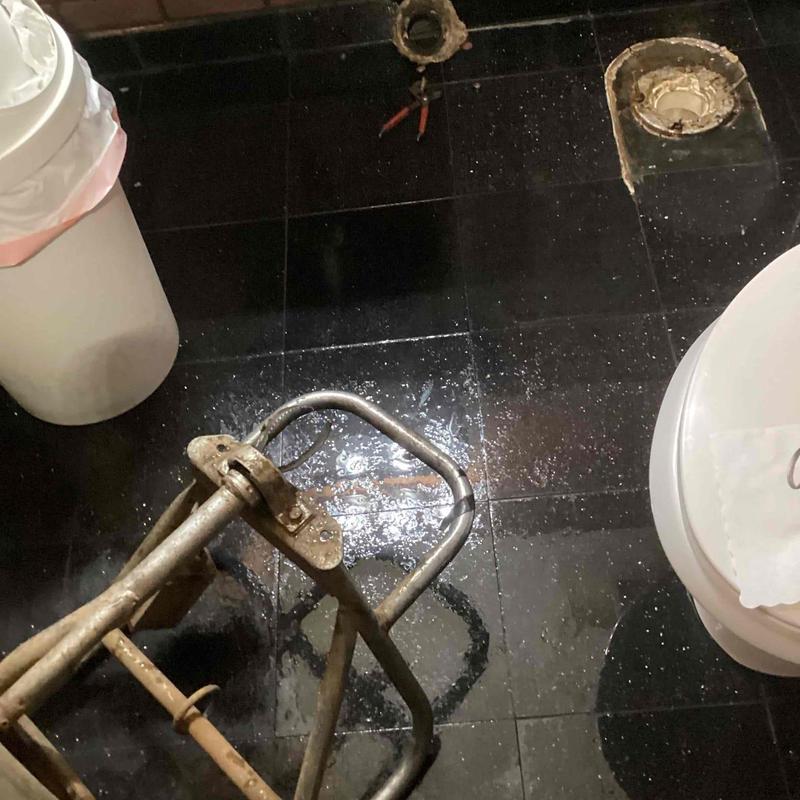 Toilet flange and mainline cable cleaning tools on floor