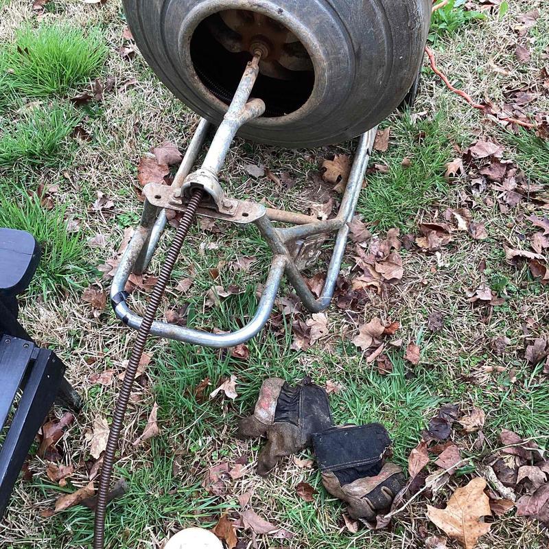 Drain auger cable fed into cleanout drum outdoors