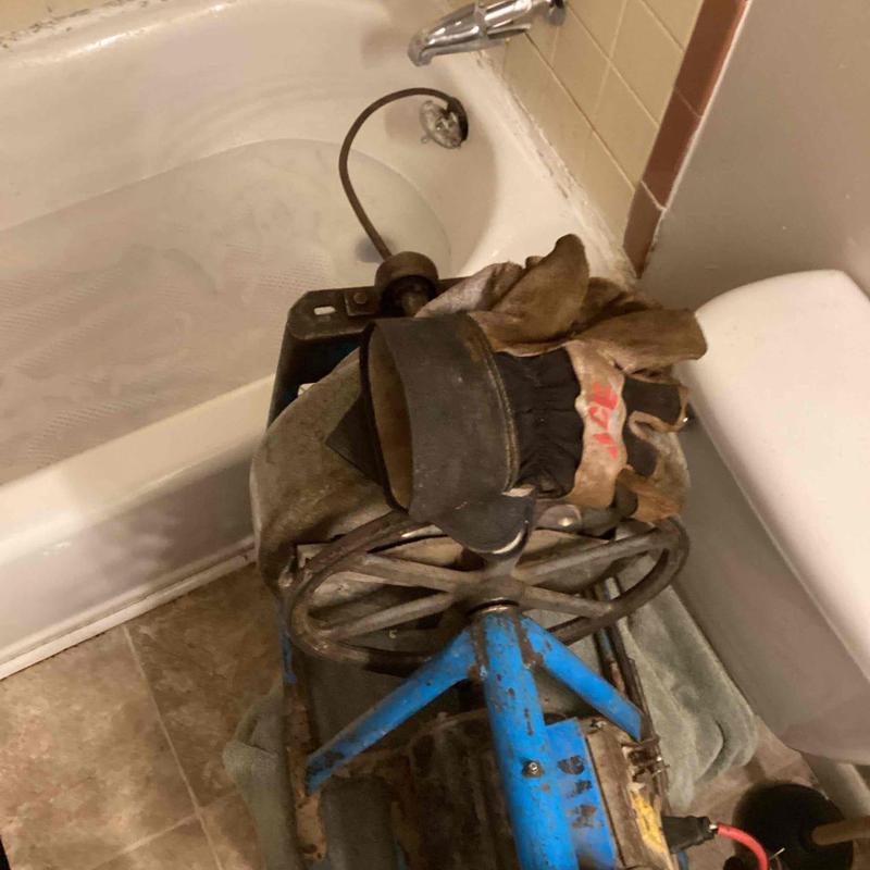 Bathtub drain cable with gloves on bathroom floor
