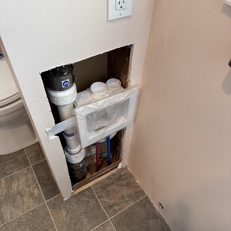 Washing machine box installation with plumbing and drain