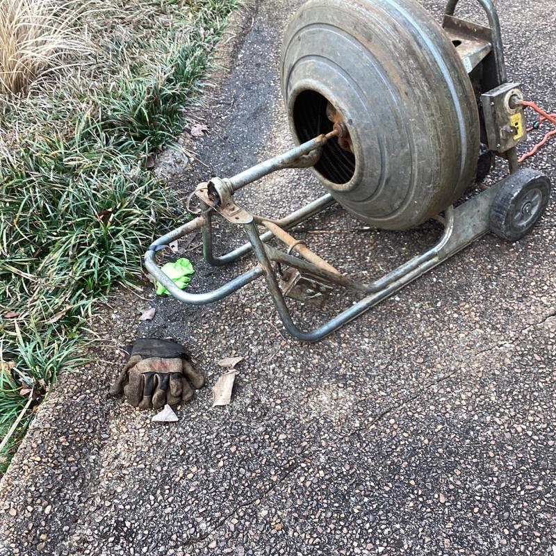 Mainline drain cleaning machine on asphalt driveway