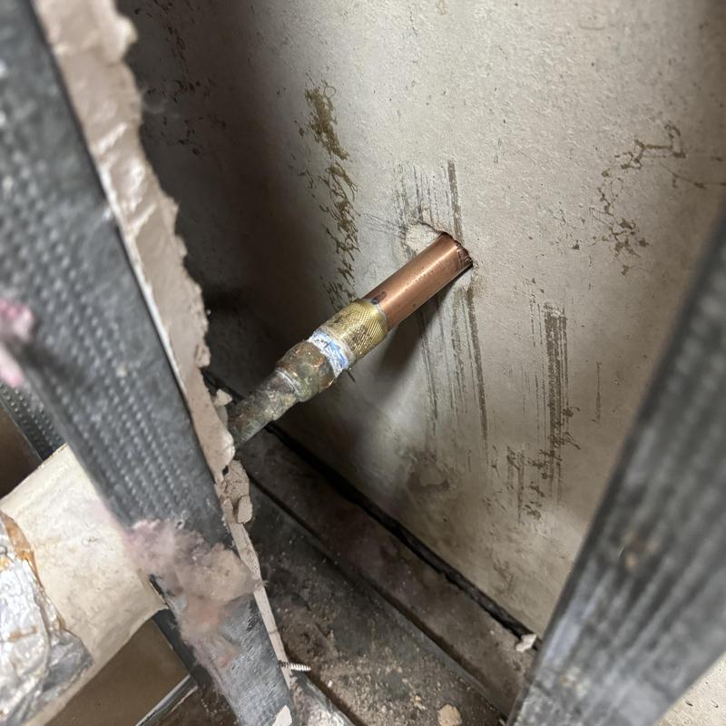 Copper pipe with soldered fitting through wall hole