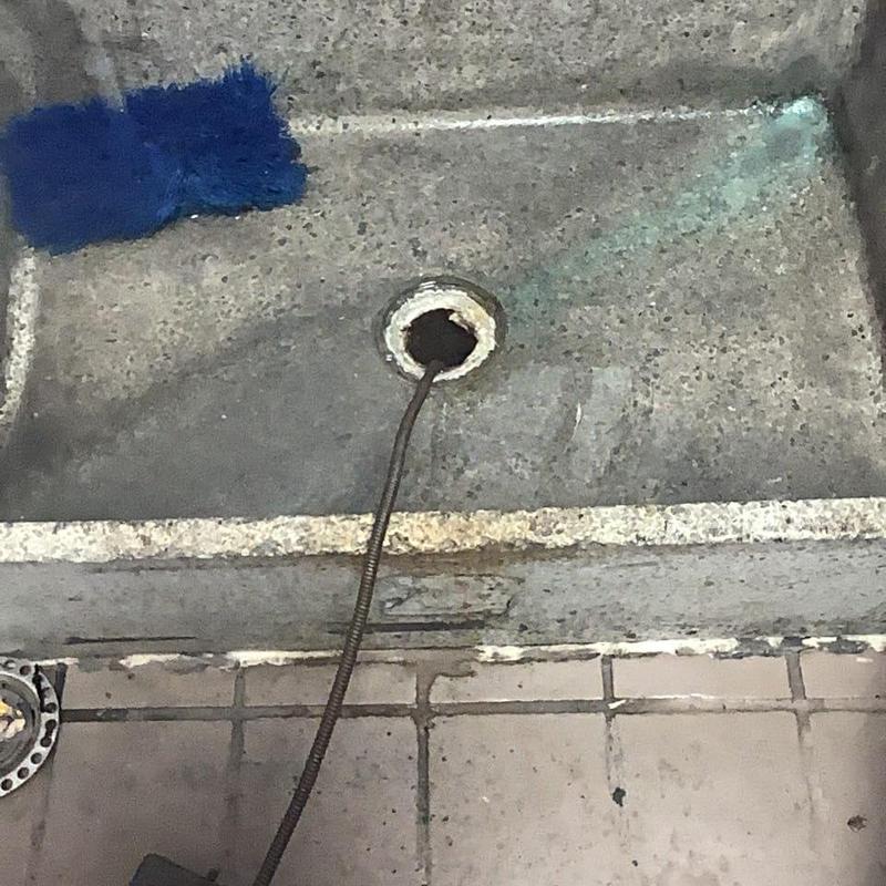 Mop sink drain with cleaning snake tool